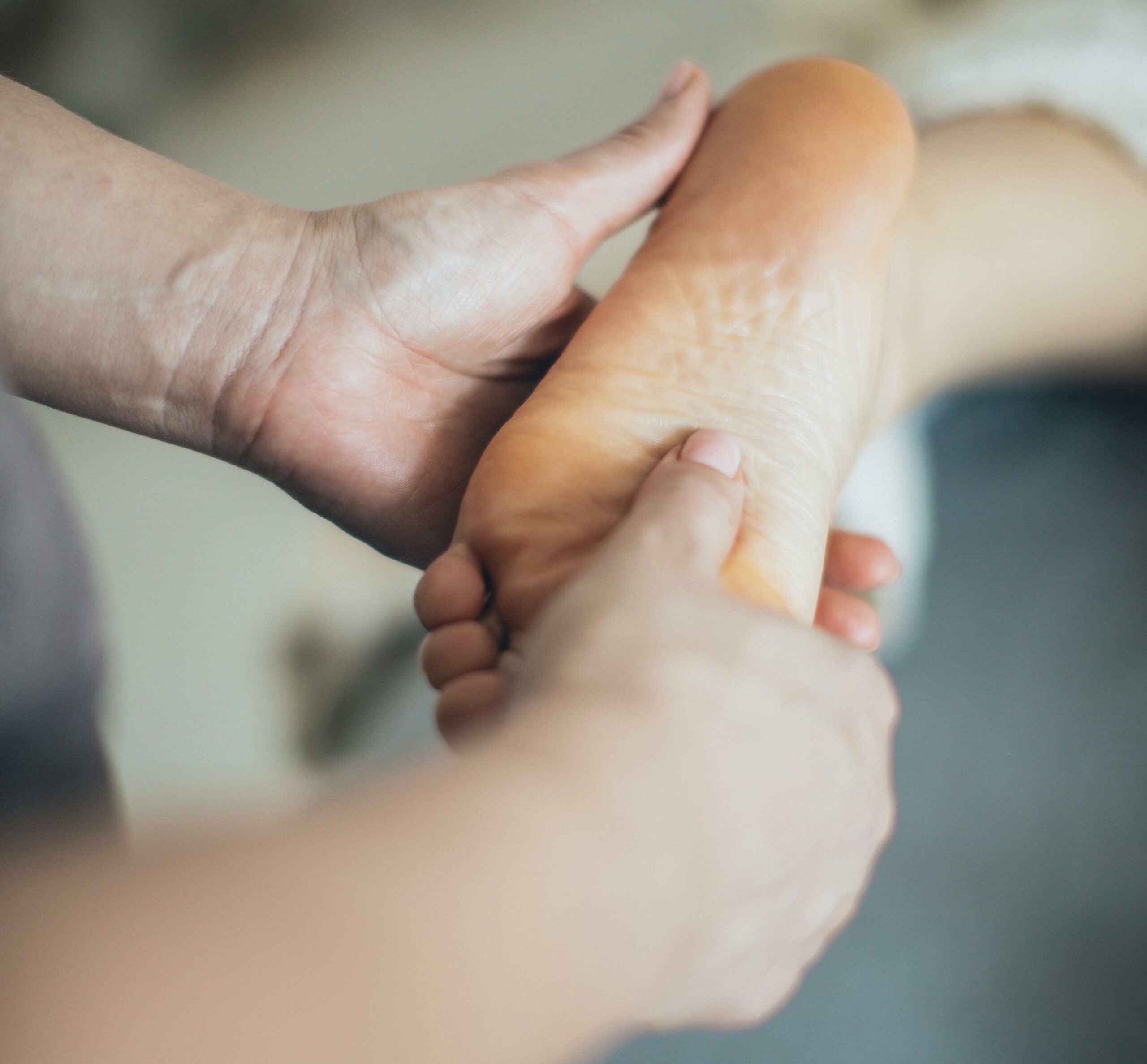 Fisioterapeuta realizando mobilização do pé em atendimento domiciliar de fisioterapia em Goiânia
